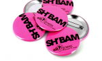 Panachage de badges ronds 56mm sur fond fluo rose.
Visuel : 'SH'BAM avec logo Elit Fitness, Retrouvez le sourire en noir sur fond fluo rose'.